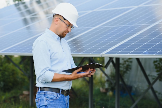 Energia solare giovane uomo d'affari vicino ai pannelli solari per le centrali elettriche