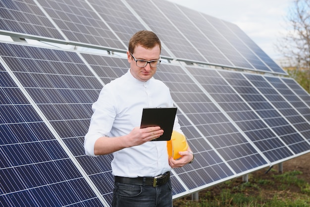 Energia solare giovane uomo d'affari in una camicia bianca vicino ai pannelli solari per centrali elettriche