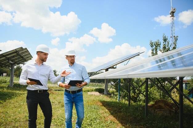 The solar farm(solar panel) with two engineers walk to check\
the operation of the system, alternative energy to conserve the\
world\'s energy, photovoltaic module idea for clean energy\
production