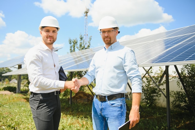 The solar farm(solar panel) with two engineers walk to check\
the operation of the system, alternative energy to conserve the\
world\'s energy, photovoltaic module idea for clean energy\
production