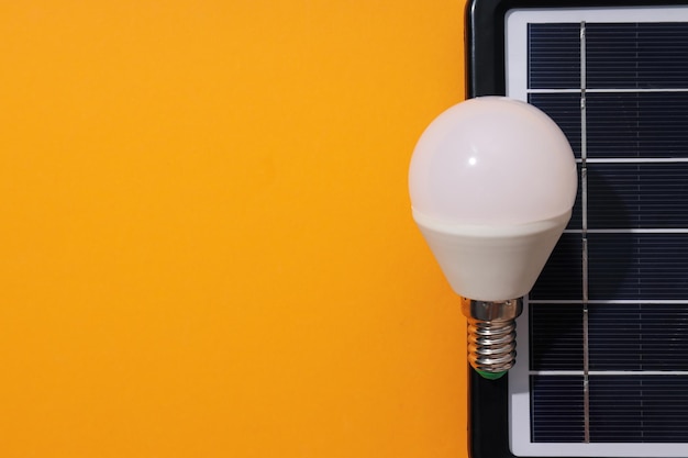 Solar panel and light bulb on yellow background space for text