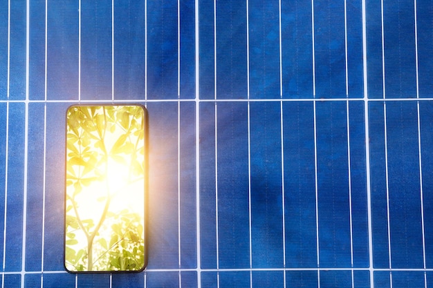 Foto pannello solare fotovoltaico fonte di energia elettrica alternativa concetto di risorse sostenibili la luce del sole che splende attraverso gli alberi è un salvaschermo per smartphone