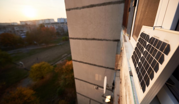 Solar panel on the window of a highrise residential building urban blurred background