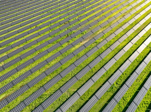 Solar panels on field in summer aerial drone view