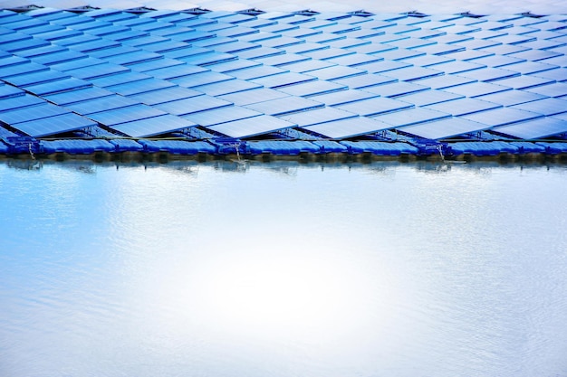 Solar panels float on the surface of the lake with the sky and sunlight reflecting
