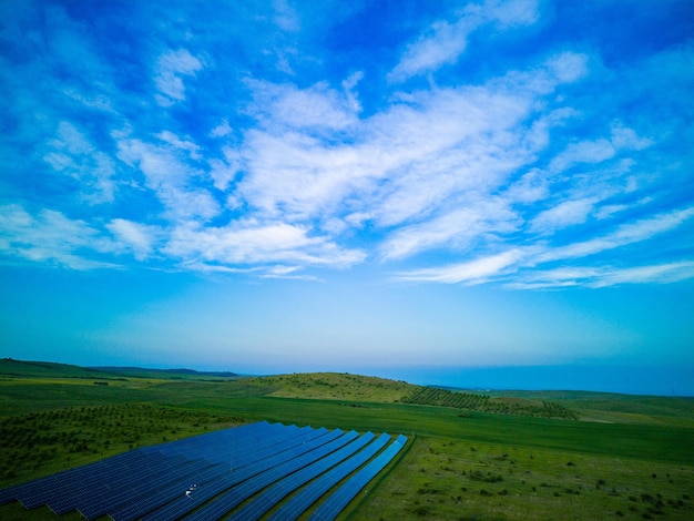 Solar panels to generate energy from the sun's rays are installed in the meadows under a blue sky with sun