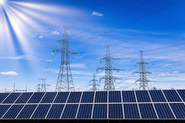 Solar panels high voltage electricity towers and sun rays