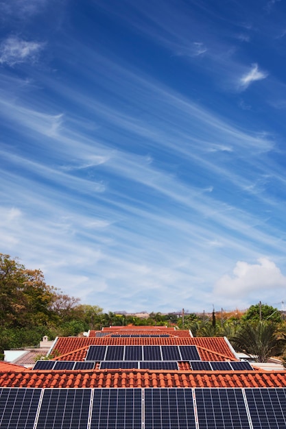 화창한 날과 흐린 날에 많은 집의 지붕에 태양 전지 패널 설치. 태양광 태양 에너지 개념 이미지입니다.