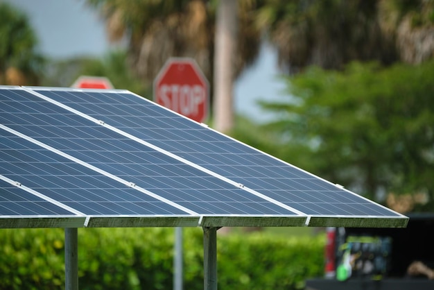 Солнечные панели, установленные на каркасе стенда возле парковки, для эффективного производства чистой электроэнергии. Фотоэлектрические технологии, интегрированные в городскую инфраструктуру для зарядки электромобилей.