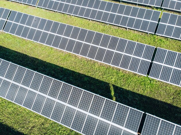 Solar Photovoltaic of aerial view, solar plant rows array of on the grass on the farm. Top view