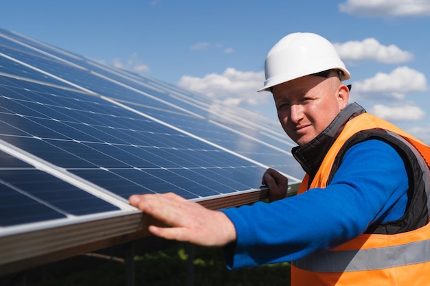 Solar plant worker inspecting photovoltaic panels for damage