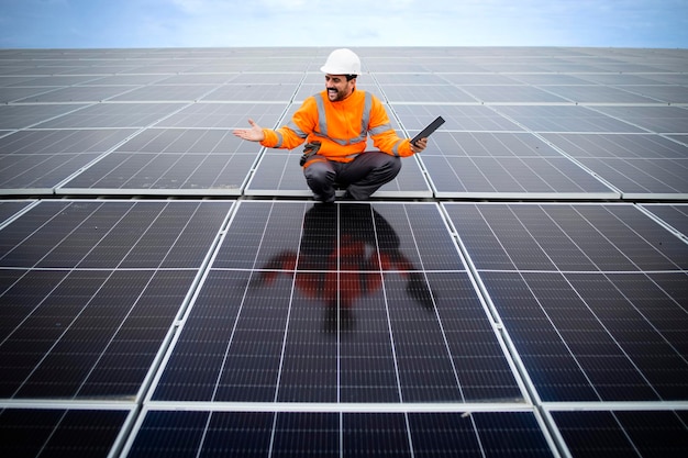 solar power plant engineer with laptop computer controlling sustainable energy production