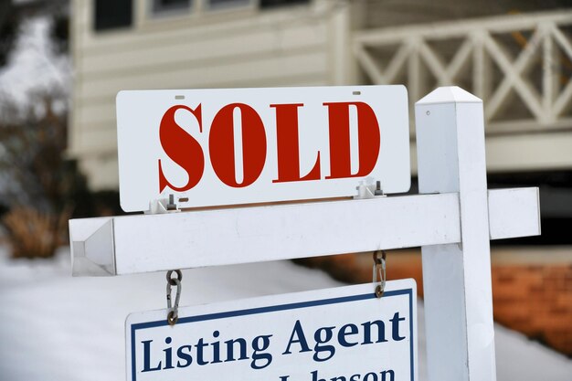 A sold sign for a sold sign is on a white post