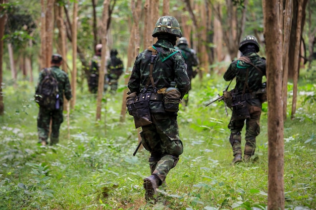 Soldaat in uniform met pistoolafronding in het bos