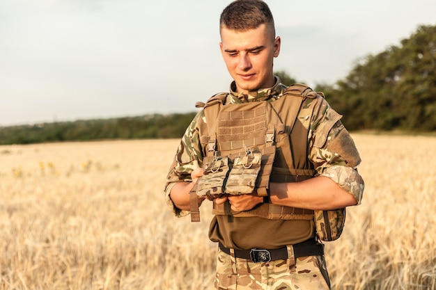 Soldaat man staande tegen een veld. Portret van gelukkige militaire soldaat in bootcamp. US Army soldaat in de missie. oorlog en emotioneel concept.