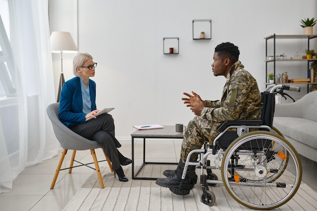 Soldaat met een handicap in een rolstoel die psycholoog bezoekt. professioneel psychologisch consult