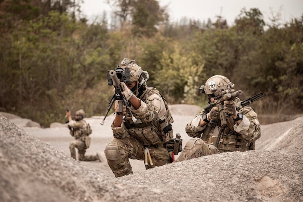 Soldaten in camouflage-uniformen richten met hun geweren klaar om te schieten tijdens een militaire operatie