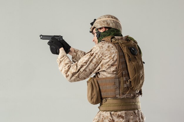 Soldato in mimetica che tiene il fucile
