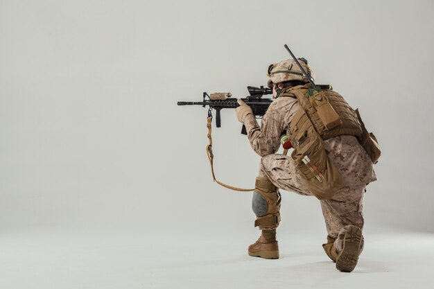 Soldier in camouflage holding rifle