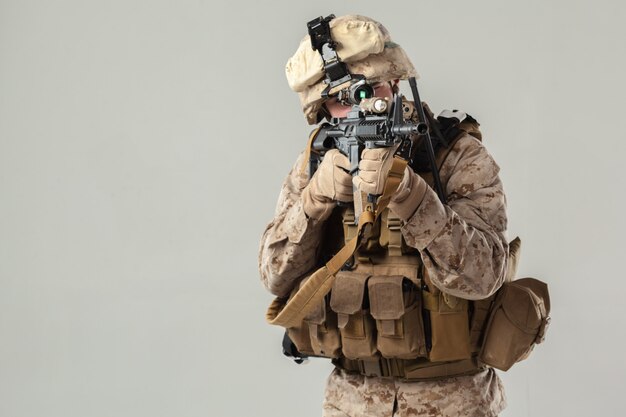 Photo soldier in camouflage holding rifle