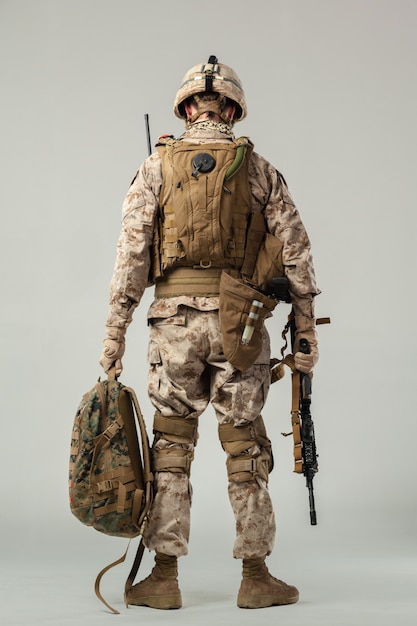 Soldier in camouflage holding rifle