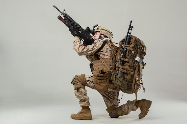 Soldier in camouflage holding rifle