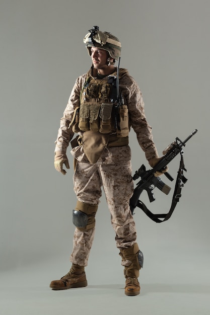 Soldier in camouflage holding rifle