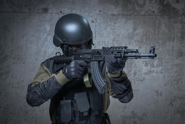 Soldier in helmet with automatic rifle in hands