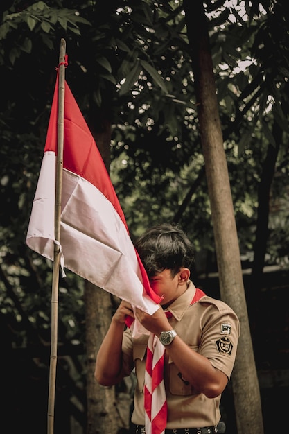 Photo soldier holding flag against tree