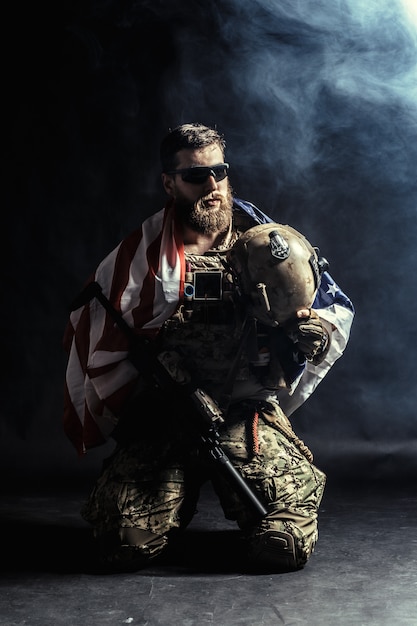 Soldier holding machine gun with national flag