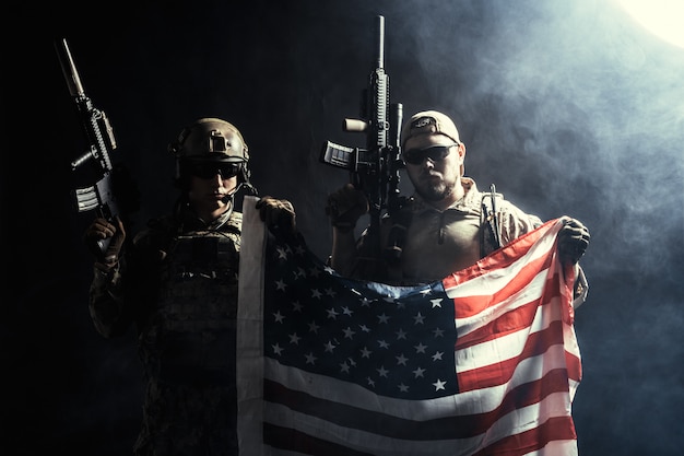 Soldier holding machine gun with national flag