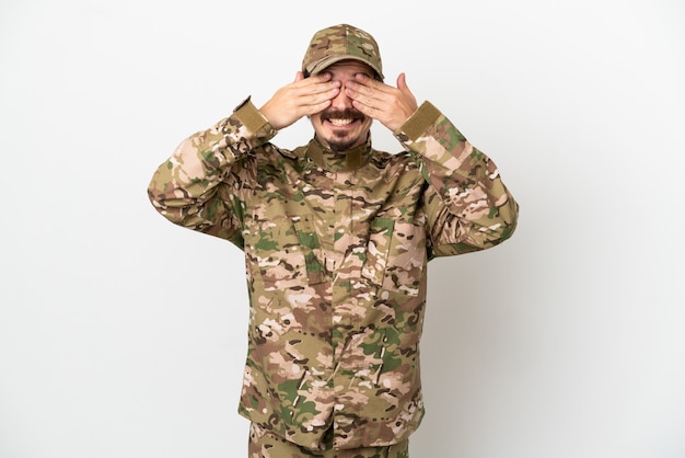 Soldier man isolated on white background covering eyes by hands