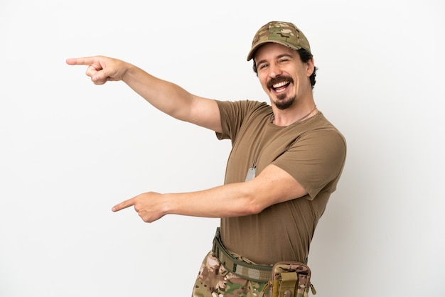 Soldier man isolated on white background pointing finger to the side and presenting a product