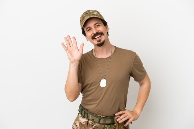 Soldier man isolated on white background saluting with hand with happy expression