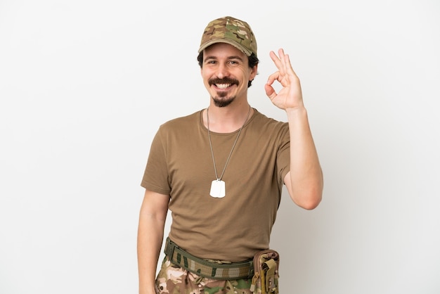 Uomo soldato isolato su sfondo bianco che mostra segno ok con le dita