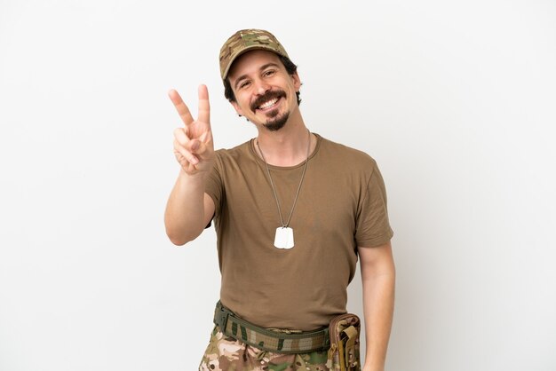 Soldier man isolated on white background smiling and showing victory sign