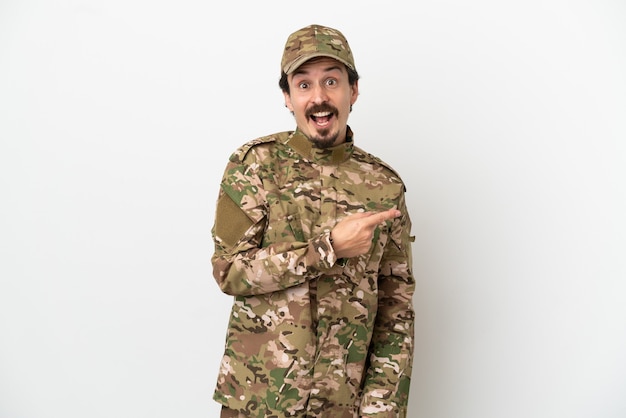 Soldier man isolated on white background surprised and pointing side