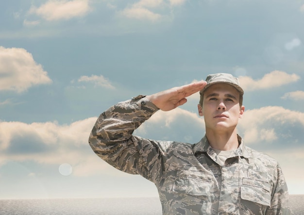 Soldier man raising arm against sky background
