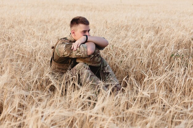 Soldier man standing against a field