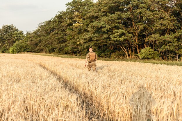 Soldier man standing against a field