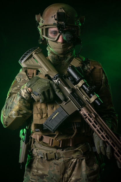Солдат в военной одежде с прибором ночного видения и на темном фоне