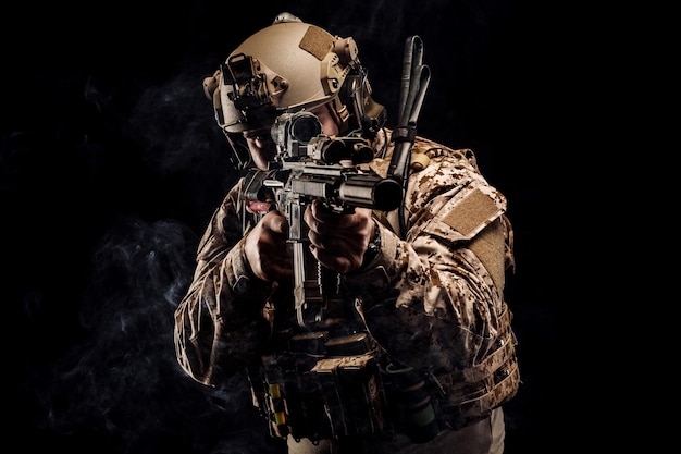 Soldier or private military contractor holding rifle Image on a black background war army weapon technology and people concept