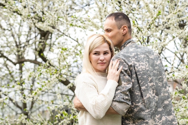 Soldier reunited with wife in park.