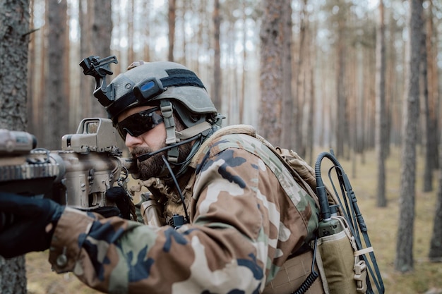 Foto un soldato in una speciale uniforme militare con un elmetto in testa e con un fucile da cecchino