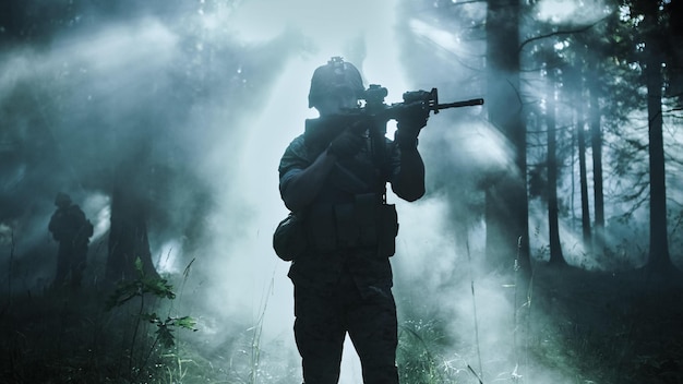 A soldier stands in a dark forest with a foggy background.