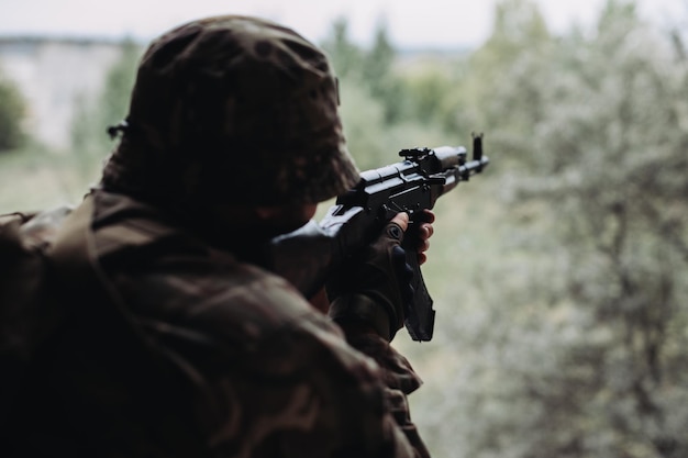 Soldier in war with weapons in his hands aim at the enemy