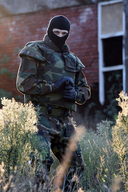 The soldier with gun is outdoor in nature