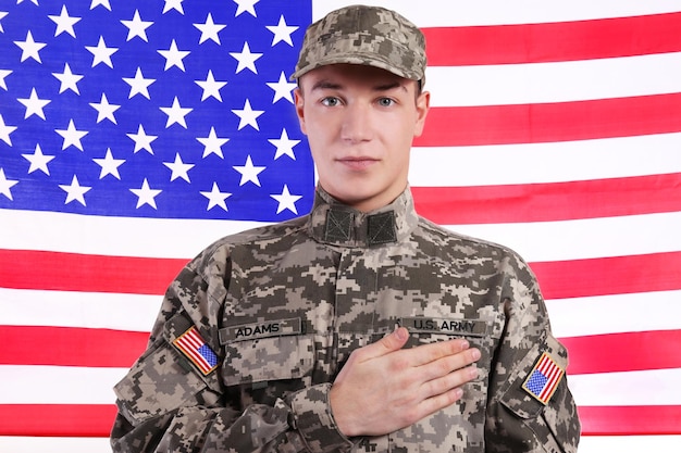 Soldier with hand on heart against USA flag