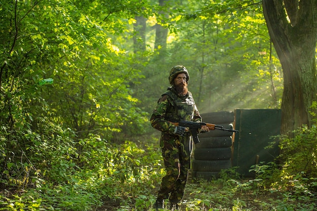 Soldier with rifle in forest