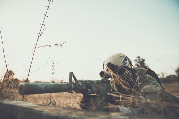 Photo soldier with weapon behind bunker